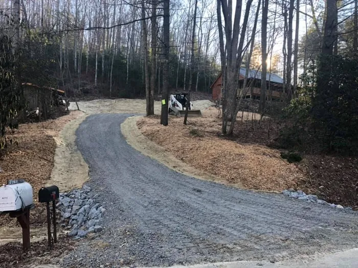 Finished gravel driveway with riprap edging and a new mailbox