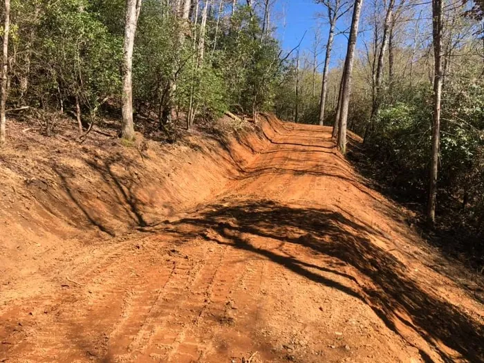 Freshly cut roadbed through the woods shaped out of red clay